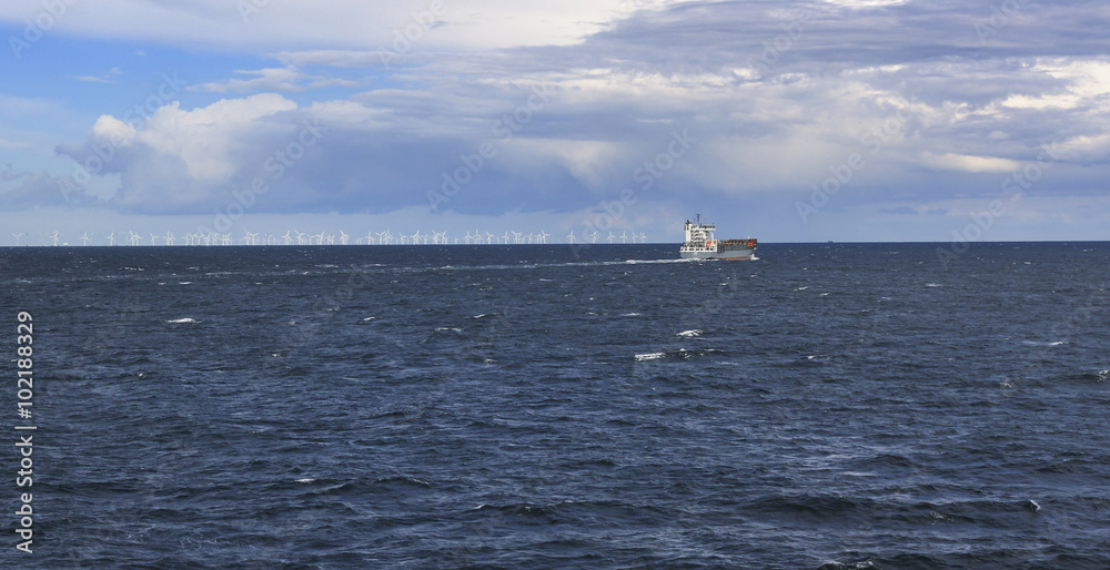 Ship in the sea with windmill on horizont