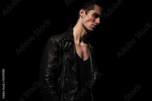 portrait of rocker in black leather posing in dark studio