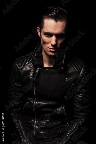 sexy biker in black leather jacket posing in dark studio backgro © Viorel Sima