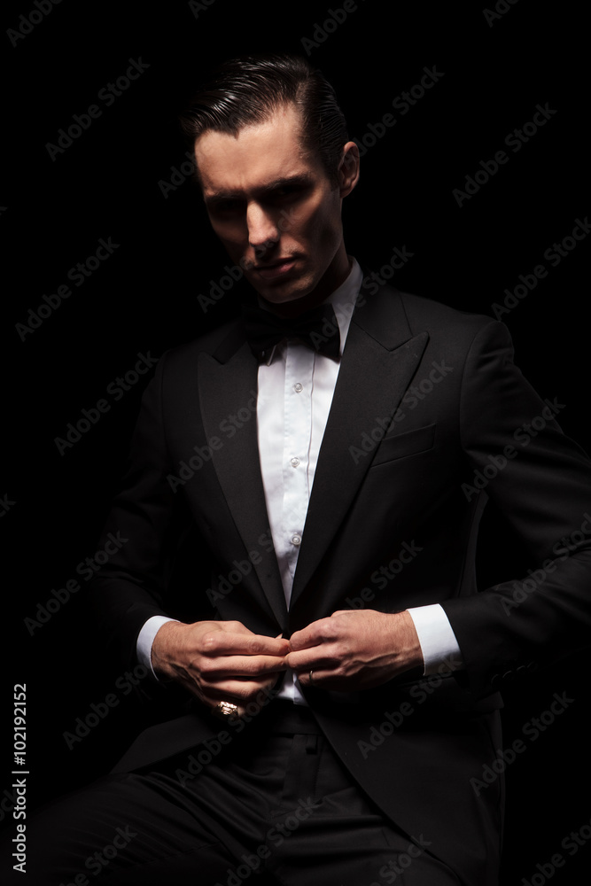 classy businessman in black suit posing seated in dark studio classy businessman in black suit posing seated in dark studio