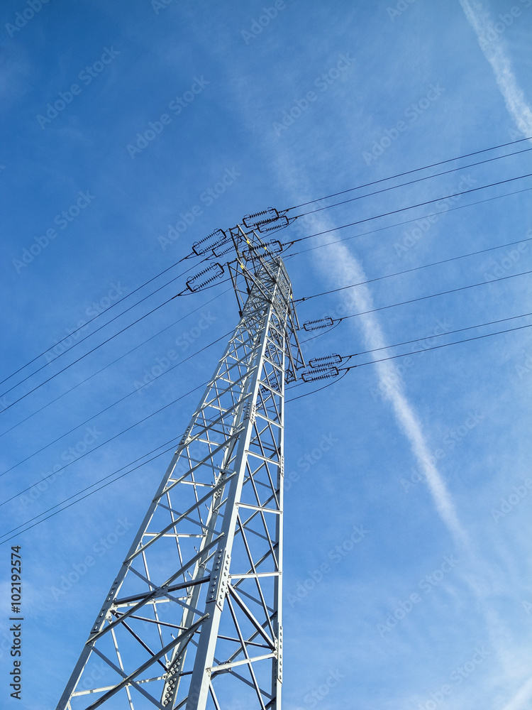 High voltage pylon against blue sky