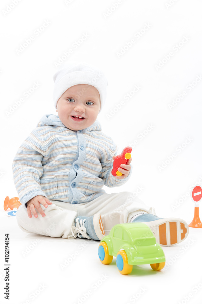 caucasian baby boy child playing with cars warm clothing hat sitting isolated on white studio shot caucasian baby boy child playing with cars warm clothing hat sitting isolated on white studio shot