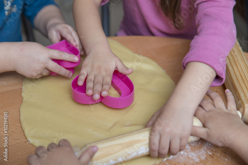 Children hands rolling out dough