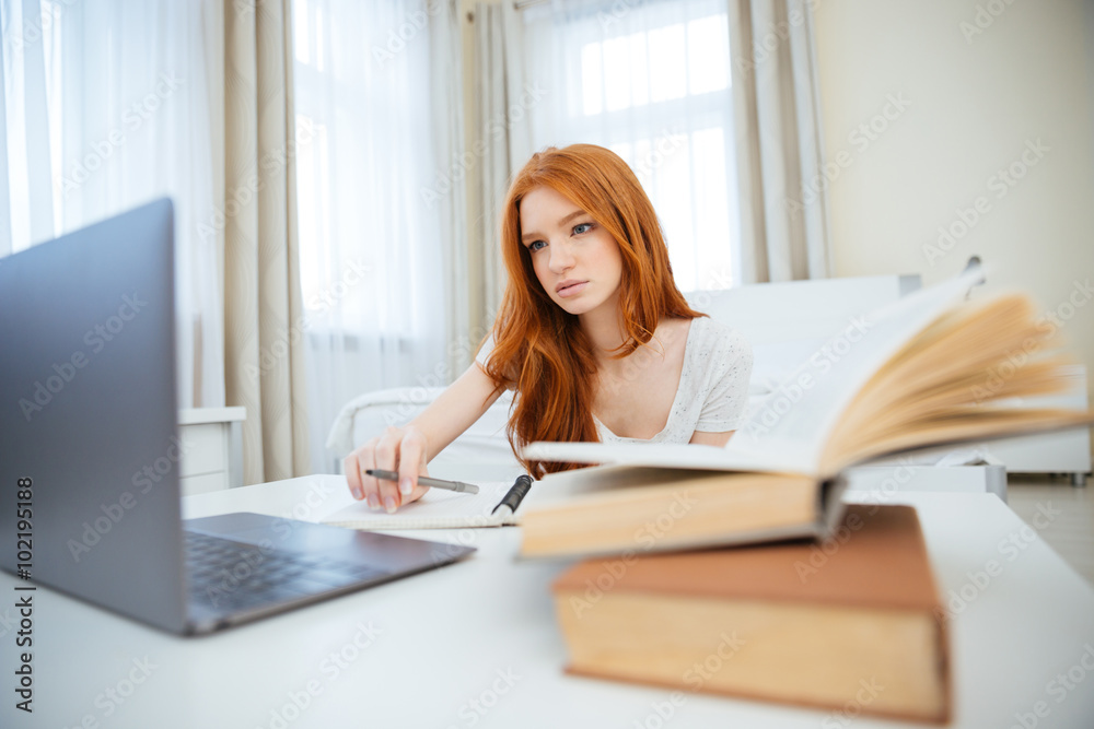 Woman sitting at the table with her homework Woman sitting at the table with her homework