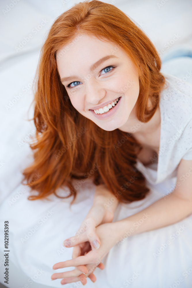 Smiling woman lying on the bed at home Smiling woman lying on the bed at home