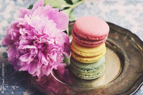 Pile of colorful macaron cookies and peony flowers, vintage styl photo