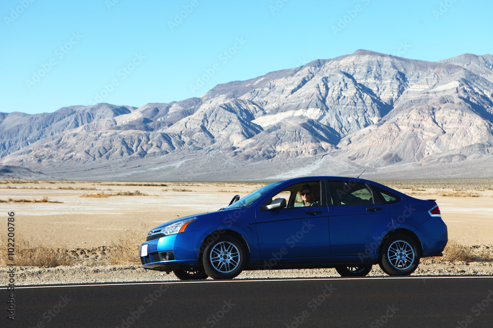 Voiture sur route longeant le désert