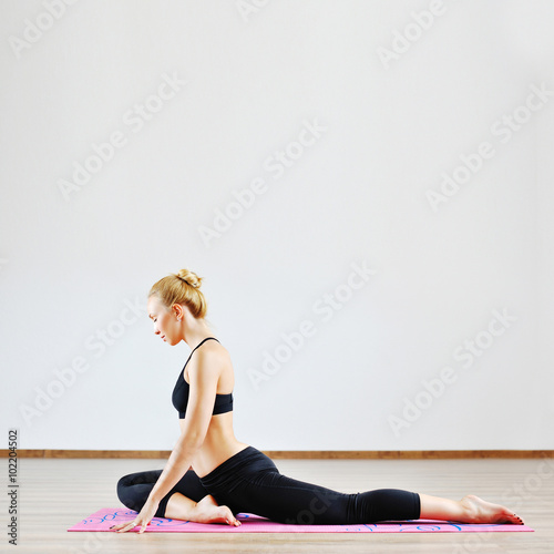 Beautiful woman with high body flexibility exercising in the gym