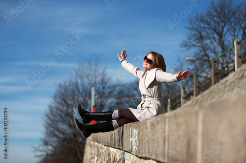 Beautiful girl sitting on the street and dreaming of flying photo