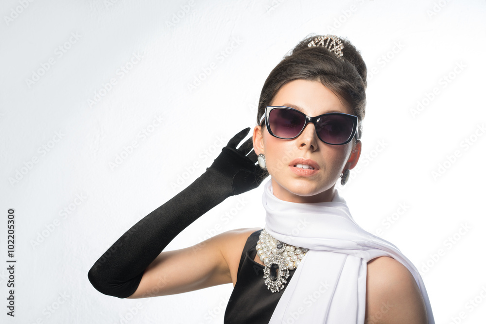 Young girl - brunette in retro - glasses, a black dress and a white scarf. Young girl - brunette in retro - glasses, a black dress and a white scarf.