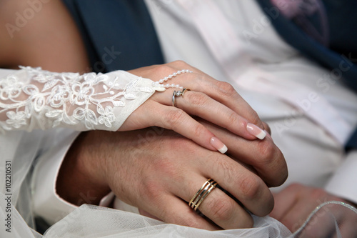 bride and groom show their hands wearing wedding rings