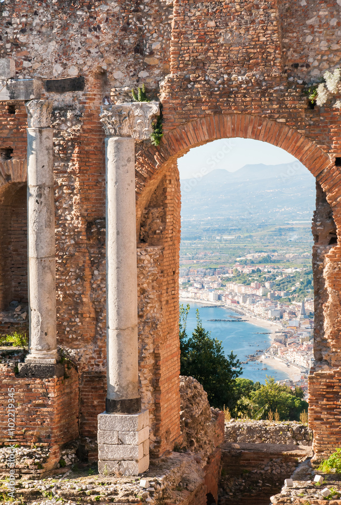 View of some columns and one arch in the scene of the greek theater in Taormina