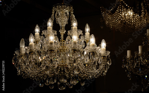 Brass chandelier with crystal. Lighted chandelier with crystal pendants. 