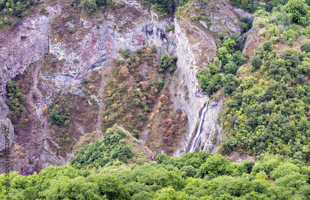 Mountain landscape waterfall flows down the cliff. The landscape in Armenia (Tatev). The canyon next to the cable car Mountain landscape waterfall flows down the cliff. The landscape in Armenia (Tatev). The canyon next to the cable car