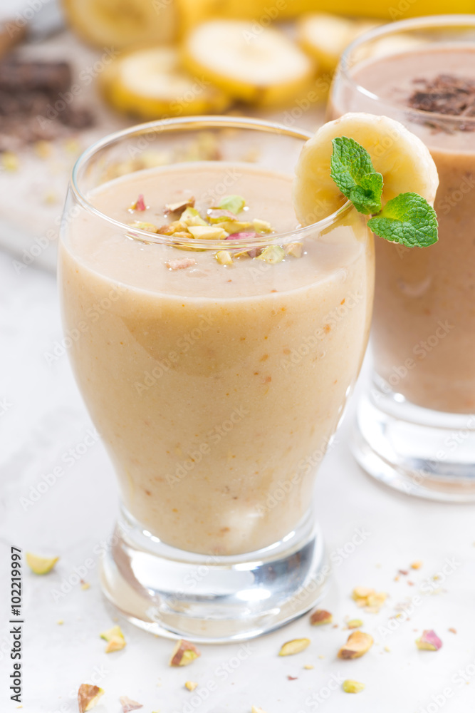 banana milkshake in a glass on white table, closeup banana milkshake in a glass on white table, closeup