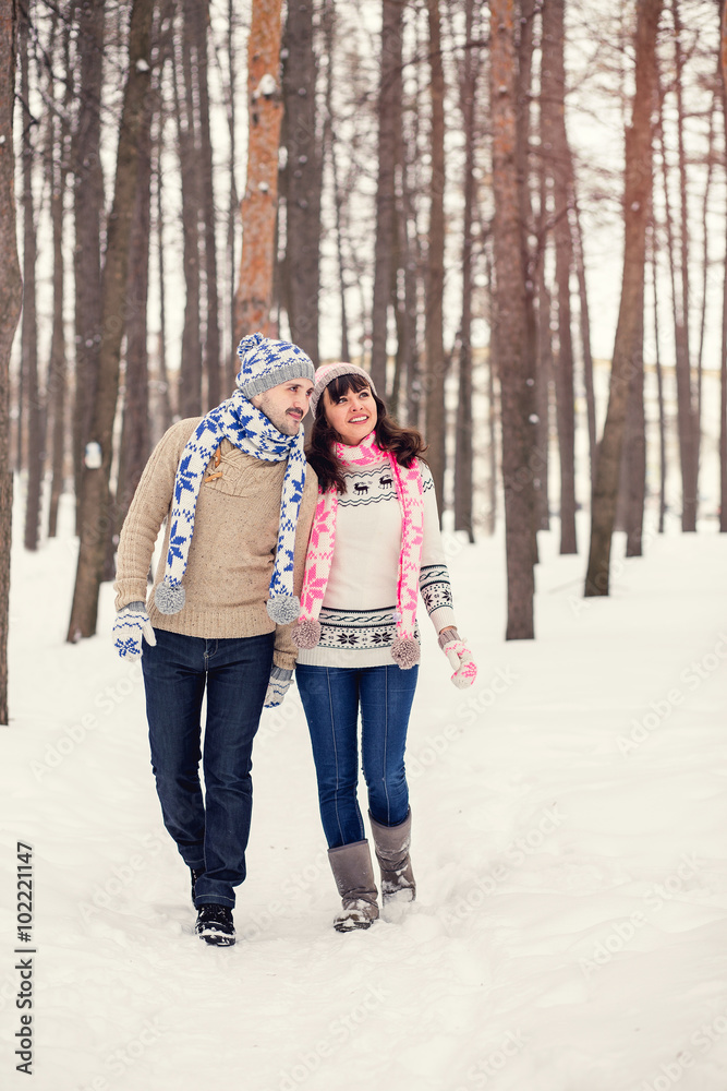 Woman and man are having walk in winter snowy countryside.