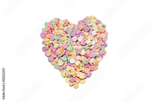 Heart candies arranged in a heart shape on a white background