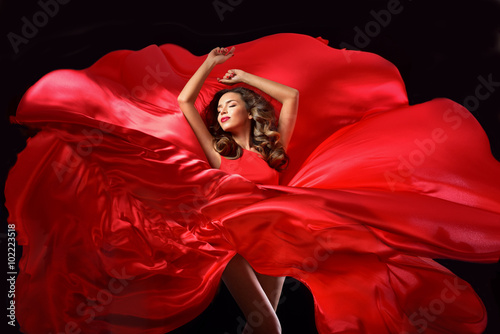 Young beauty woman in red waving flying  dress. Dancer in silk d photo