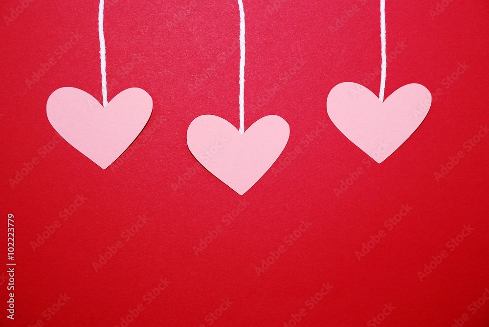 Hearts hanging from string on a red background, can be used for Valentine's Day or Mother's Day project