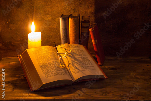 old books being read by candle light