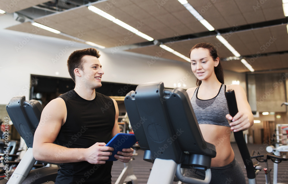 woman with trainer exercising on stepper in gym woman with trainer exercising on stepper in gym