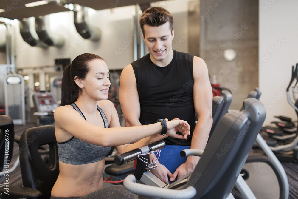 happy woman with trainer on exercise bike in gym happy woman with trainer on exercise bike in gym