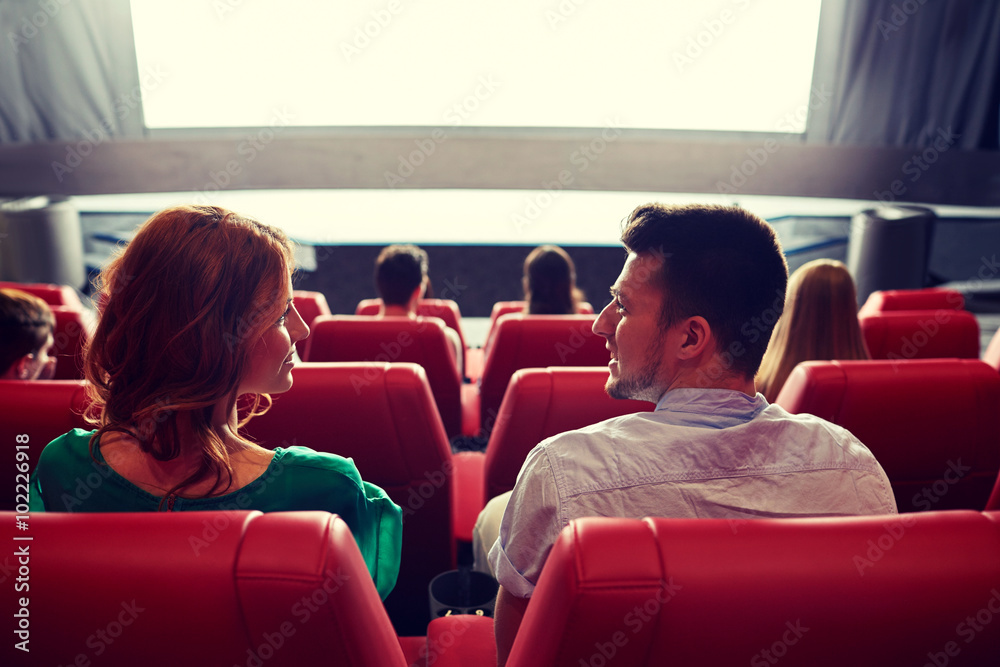 happy couple watching movie in theater or cinema