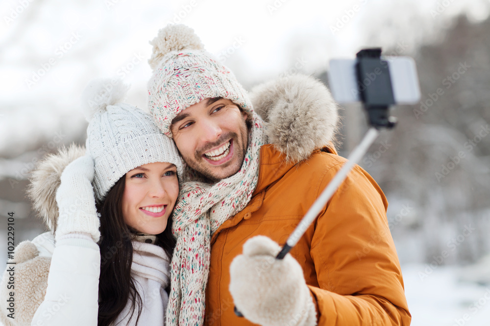 Obraz premium happy couple taking selfie by smartphone in winter