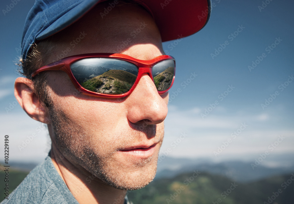 Man in sun glasses with mountain mirorred in it Man in sun glasses with mountain mirorred in it