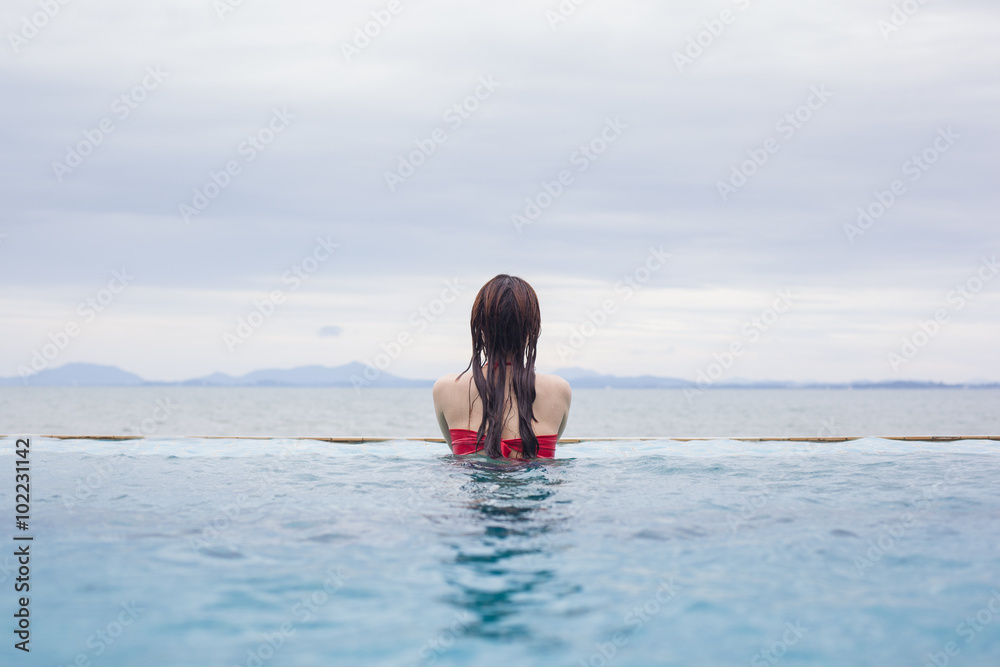 Young woman in bikini by the swimming pool