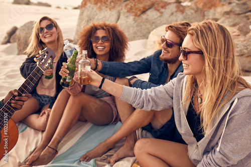 Canvas Print Group of friends cheers with beers at the beach