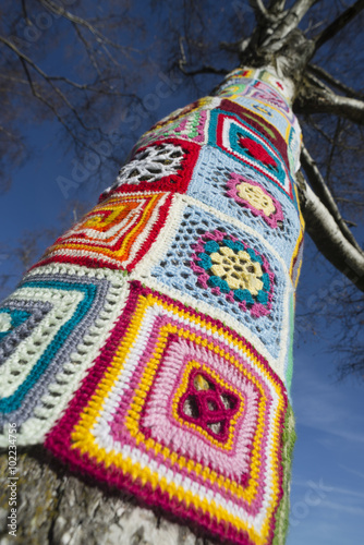 Guerilla Knitting - mit bunter Wolle umstrickter Baumstamm im Olympiapark München photo