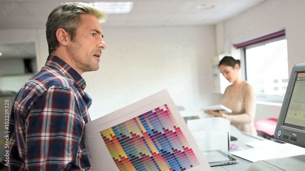 People in printing house checking color sample