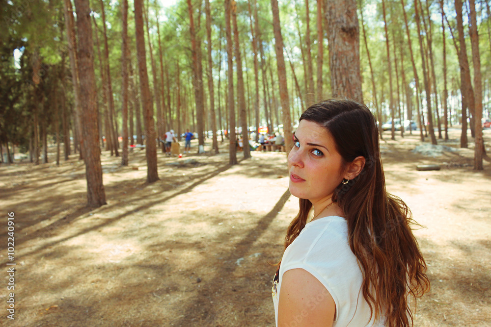 Woman looking back towards the camera in the forest