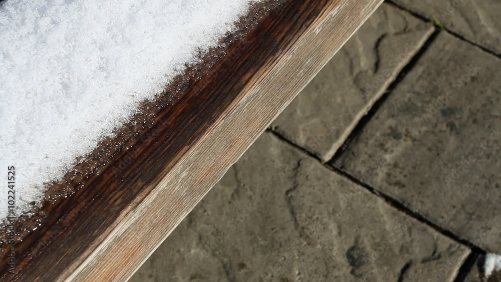 Snow melting on wooden bench. Macro shot. Snow melting on wooden bench. Macro shot.