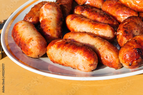 Grilled sausages on a round plate.