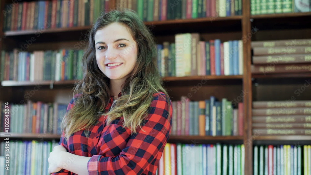 Girl standing in the library and smiling to the camera
Girl standing in the library and smiling to the camera