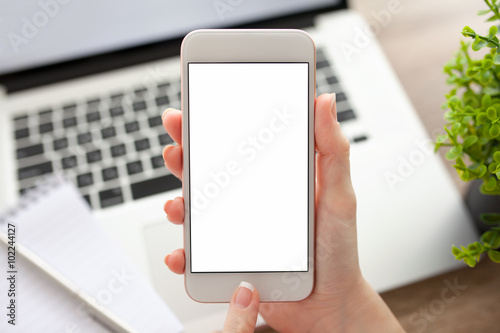female hand holding a phone with isolated screen and laptop