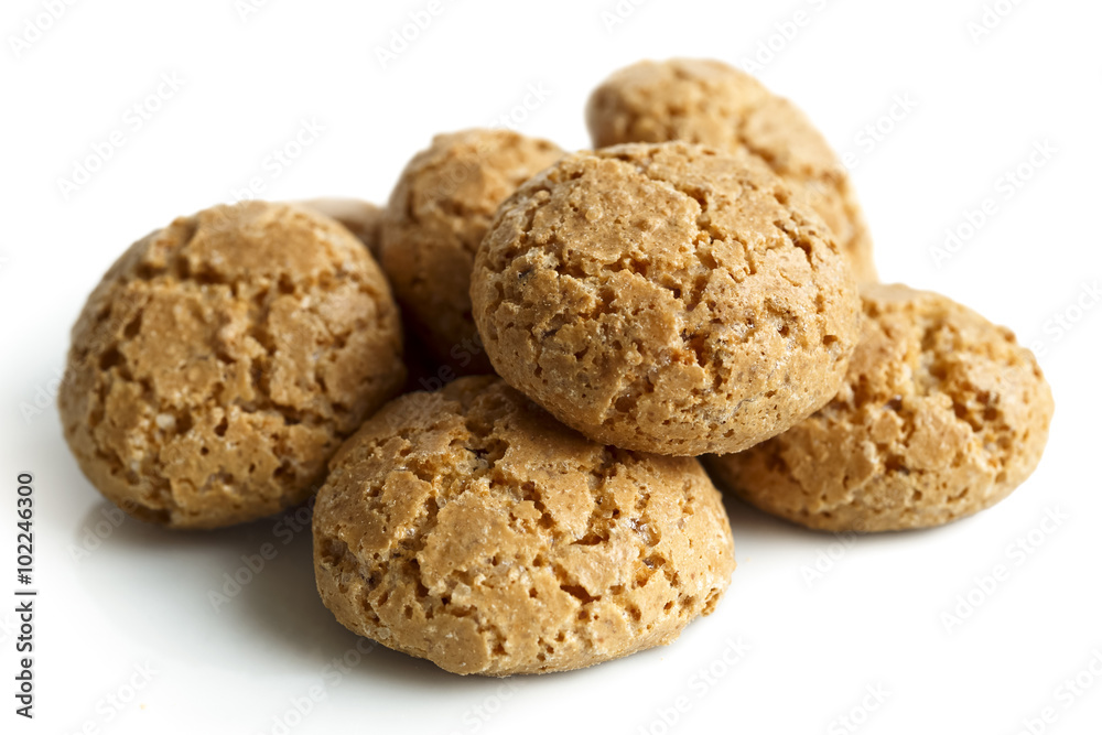 Heap of whole Italian amaretti biscuits isolated on white in pe Heap of whole Italian amaretti biscuits isolated on white in pe