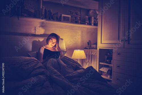 giovane ragazza legge libro a letto photo
