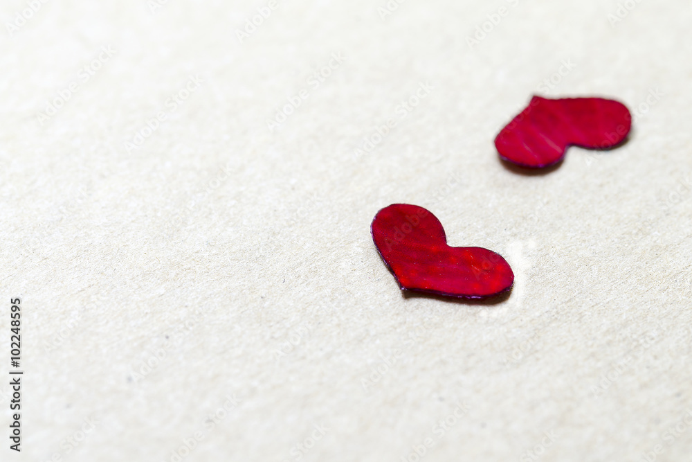 Red petal in heart shape on brown paper background Red petal in heart shape on brown paper background