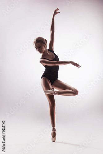 Ballerina in beige outfit posing on toes
