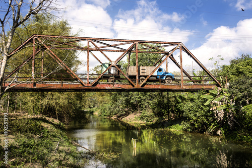 Kuba: Alter traditioneller LKW auf rostiger Brücke über ruhigem Fluss in der Mitte der kubanischen Karibik Insel