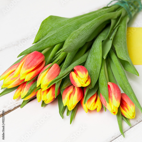 Bouquet of yellow red tulips on  wooden background