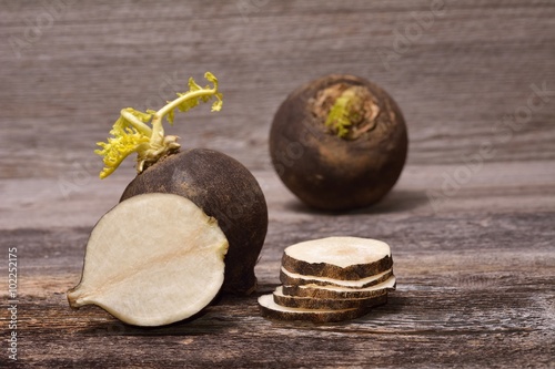 Black radish on wooden background