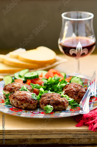 Lamb and veal cutlets with fresh vegetables salad, wine and bread