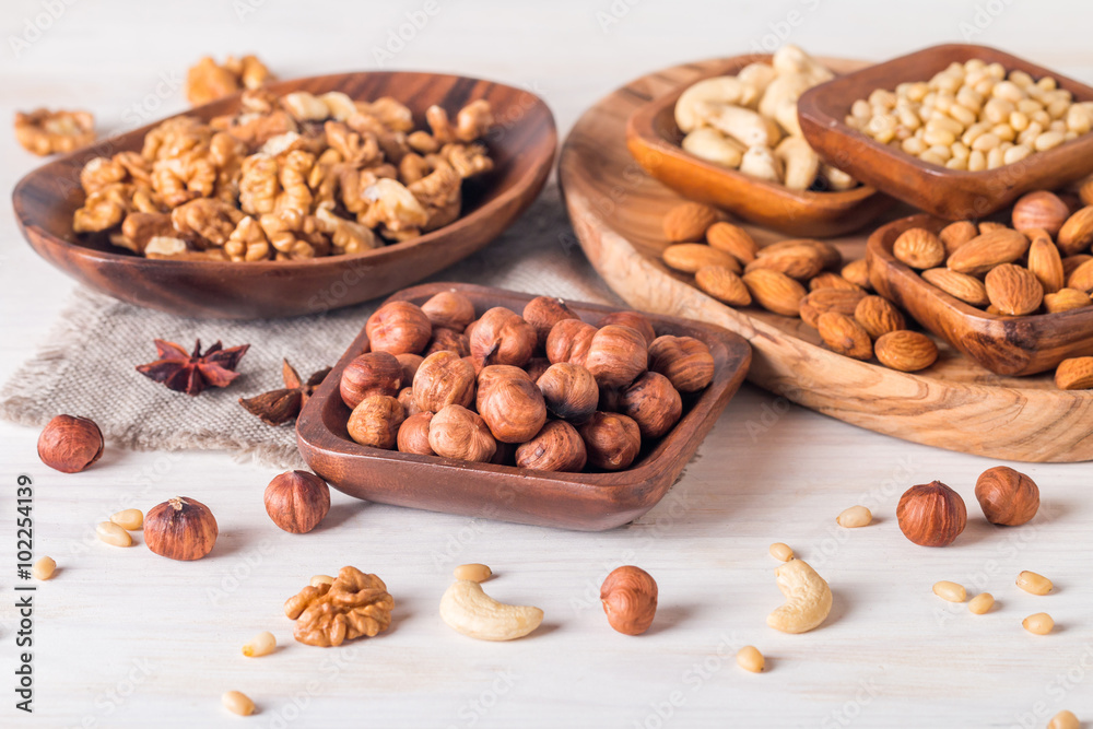 almonds, walnuts, hazelnuts cashews and pine nuts in wooden bowl almonds, walnuts, hazelnuts cashews and pine nuts in wooden bowl