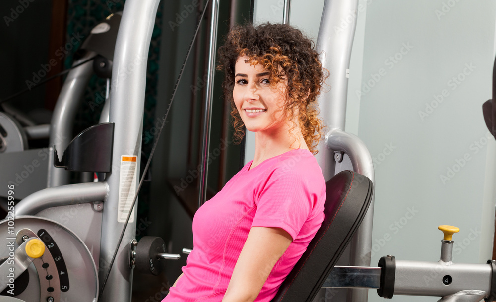 Attractive female smiling and exercising in the gym Attractive female smiling and exercising in the gym