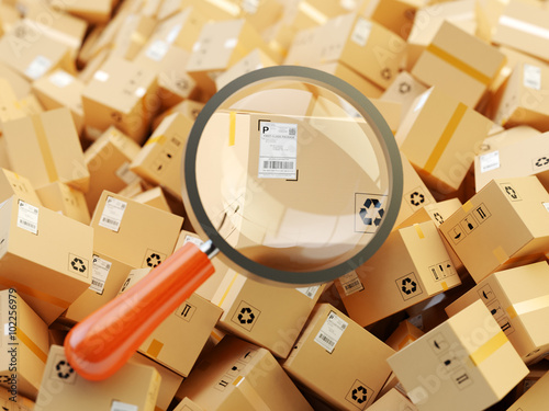 Distribution warehouse, international package shipping, global freight transportation, logistics, delivery and tracking concept, heap of cardboard boxes and magnifying glass zoom in parcel label