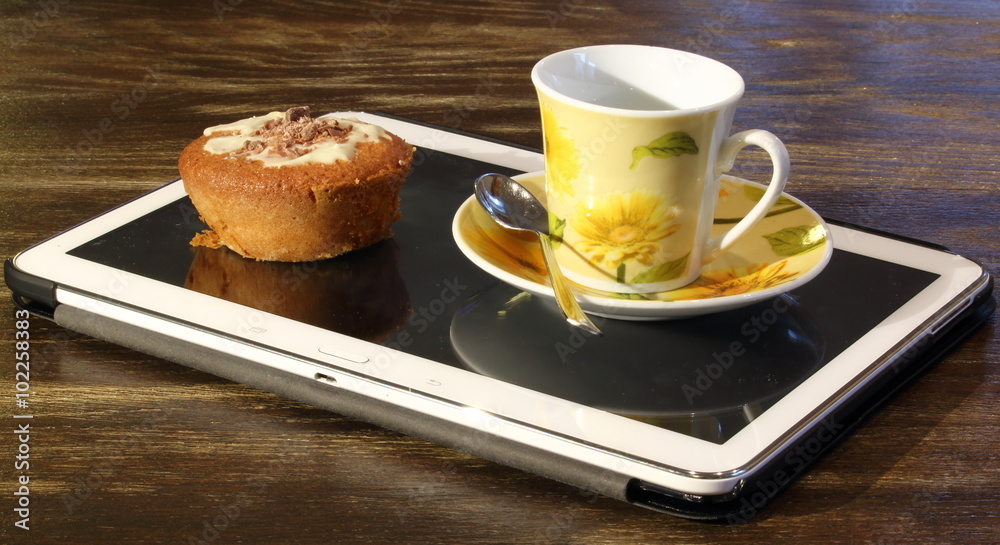 Foto Stock Tablet usato come vassoio, con tazzina di caffè e pasticcino